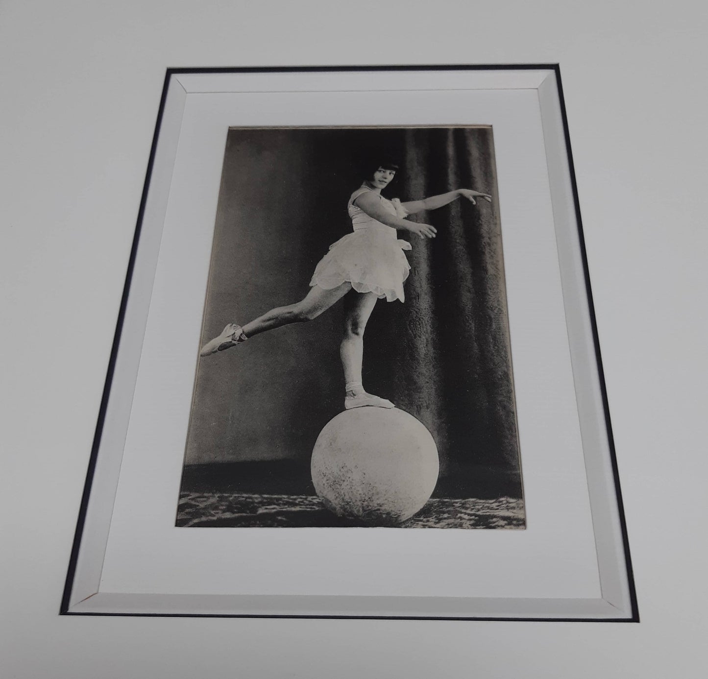 "Acrobate au ballon". Carte postale ancienne dans son encadrement.